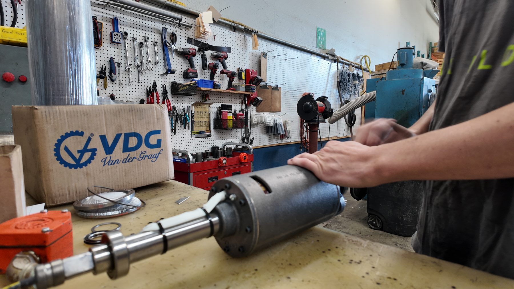 Technician rebuilding a Van der Graaf drum motor at the Fresno workbench